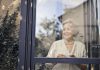 signora anziana dietro una finestra